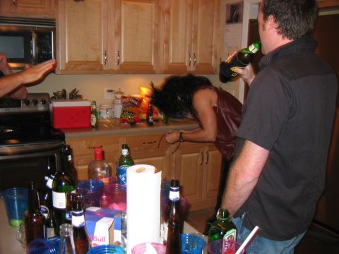 1985 Ford LTD Crown Victoria - A messy kitchen counter is covered in drinks and snacks during a party.
