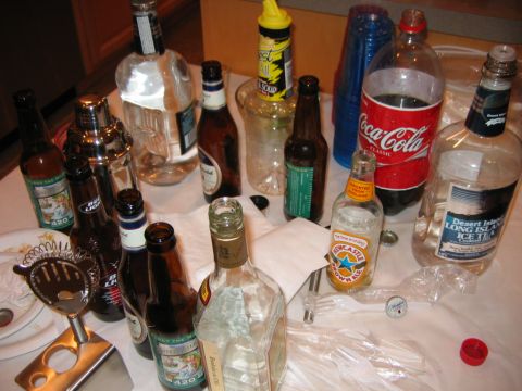 1985 Ford LTD Crown Victoria - A collection of beverage containers and party supplies are spread across a table.