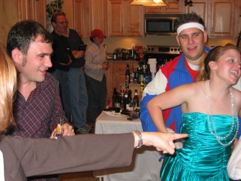 1985 Ford LTD Crown Victoria - A group of people are socializing in a kitchen area during a party event.