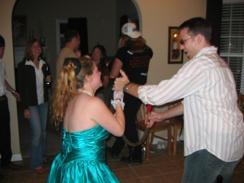 1985 Ford LTD Crown Victoria - A group of people are enjoying themselves at a party, with some dancing and others holding drinks.