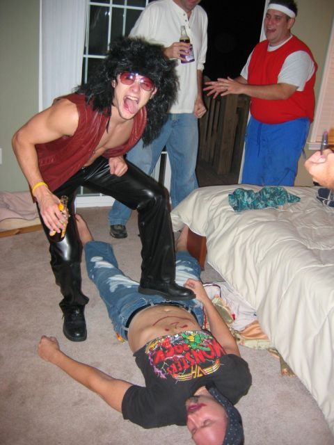 1985 Ford LTD Crown Victoria - A group of friends appear to be having a lively time at a party, with one person playfully posing over another.