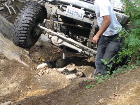 1990 Ford Bronco - A vehicle with a Washington license plate navigates a challenging rocky trail, demonstrating its off-road capabilities.