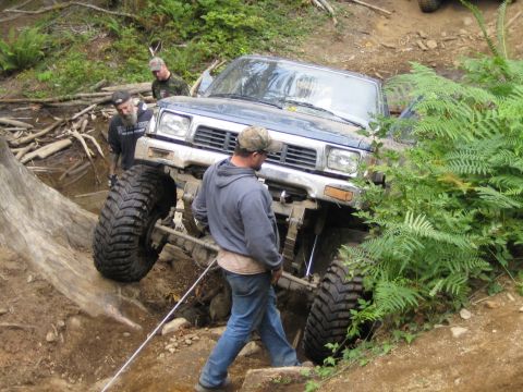 1990 Ford Bronco - Off-road vehicle attempts to navigate a difficult obstacle on a trail.