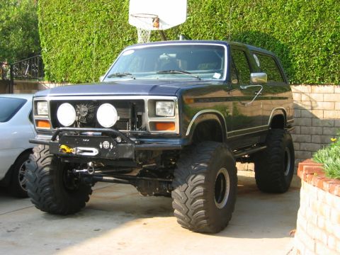 1985 Ford Bronco - This heavily modified Ford Bronco features massive tires and a custom front bumper with a winch.