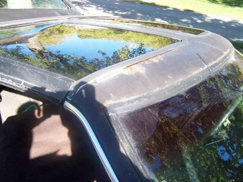 1978 Ford Mustang II - The vinyl roof and sunroof frame of a car show signs of age and wear, with rust visible on the edges.