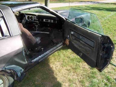 1978 Ford Mustang II - The interior of a car is visible with the driver's side door open, revealing the dashboard and seats.