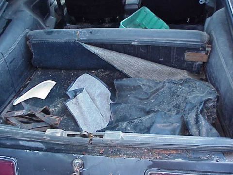 1978 Ford Mustang II - Trunk interior of a 1978 Ford Mustang II, containing various items and debris.
