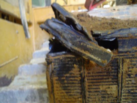 1966 International School Bus - This is a close-up view of a heavily damaged and dirty battery, likely removed from heavy equipment.