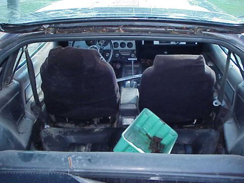 1978 Ford Mustang II - The interior of a car shows two bucket seats and a dashboard with a green container in the back.