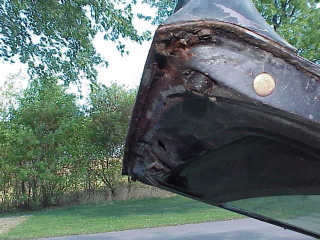 Rusted car door frame with a circular emblem