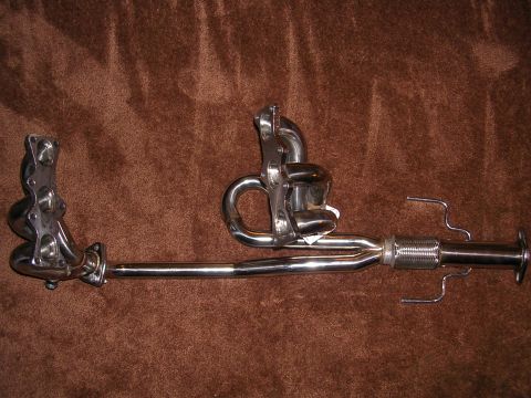 1996 Ford Probe - Chrome exhaust headers and flexible pipe assembly shown against a brown textured background.