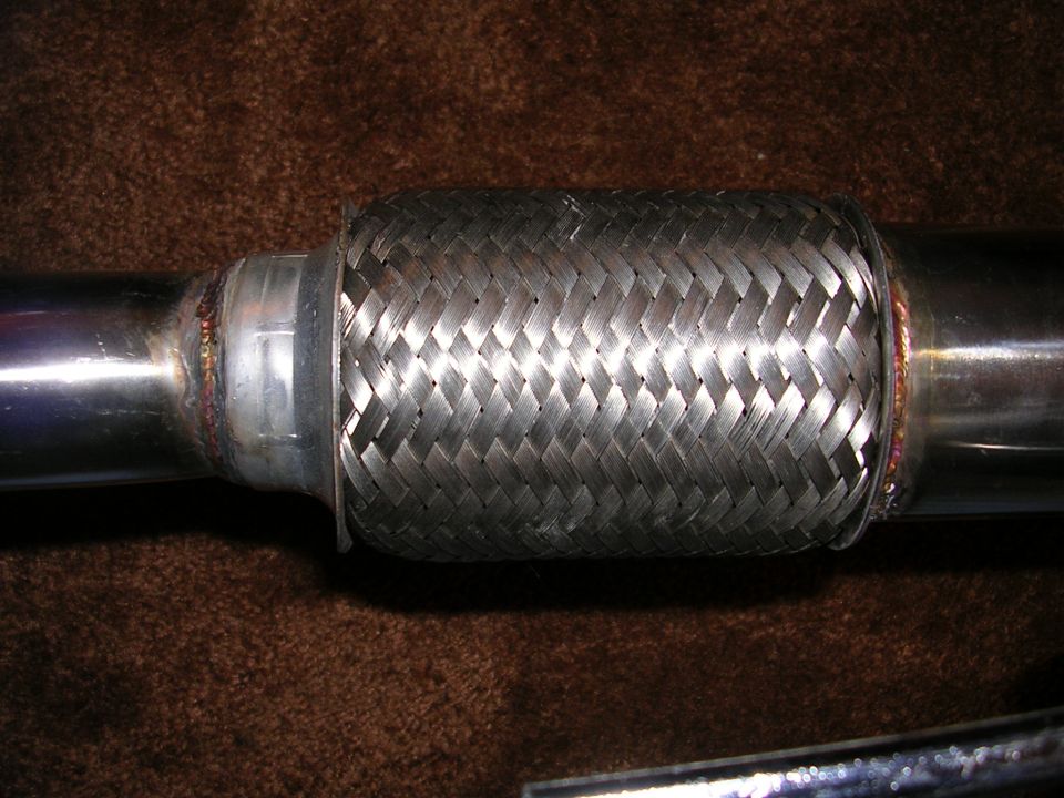 Close-up of braided stainless flex coupling welded into a polished exhaust pipe