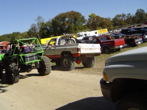 1979 Ford Bronco - Several off-road vehicles are gathered at an outdoor event, with a clear blue sky overhead.