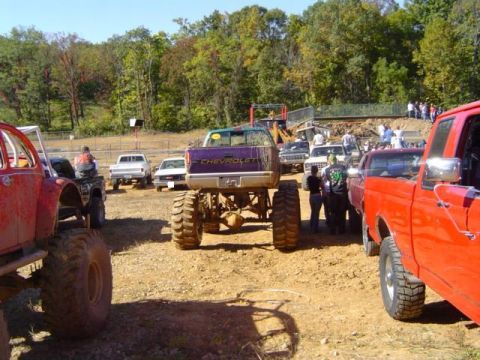 1979 Ford Bronco - A sunny day at a mud bogging event with several off-road vehicles gathered.