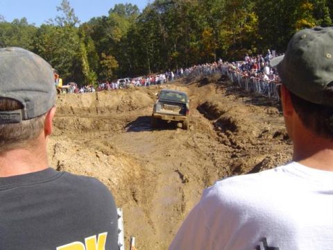 1979 Ford Bronco - Spectators watch an off-road vehicle tackle a challenging mud course during an event.