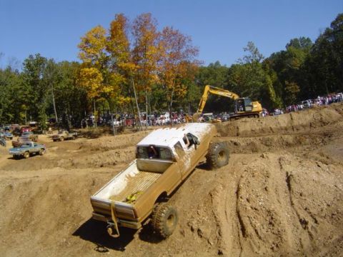 1979 Ford Bronco - Vehicles navigate a challenging off-road course during an event with spectators watching.