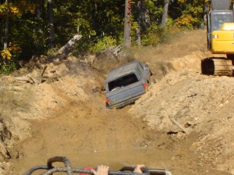 1979 Ford Bronco - A 1979 Ford Bronco is stuck in a mud pit, with an excavator visible to the right.