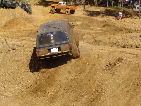 1979 Ford Bronco - Off-road vehicles tackle a challenging dirt course during a mud bash event.