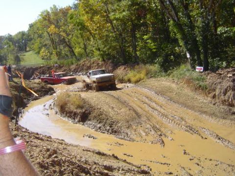 1979 Ford Bronco - Trucks tackle a challenging mud pit during an off-road event.