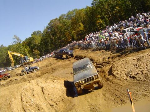 1979 Ford Bronco - Vehicles tackle a challenging course with a large crowd observing the action.
