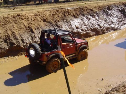 1979 Ford Bronco - Off-road vehicle navigates a muddy track during an event.