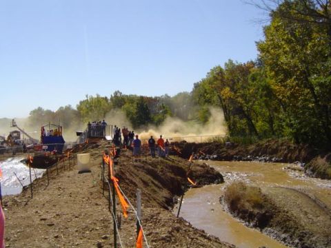 1979 Ford Bronco - Spectators watch as vehicles navigate a muddy course during an event, with a Supermotors.net logo in the corner.