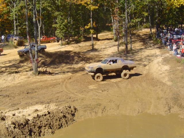 Lifted car with large tires on muddy track
