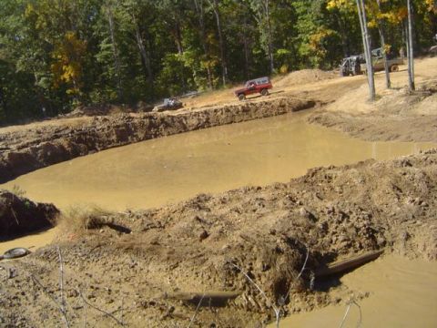 1979 Ford Bronco - Multiple off-road vehicles traverse a muddy landscape with a prominent mud pit.