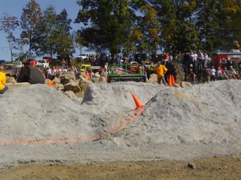 1979 Ford Bronco - A crowd watches as off-road vehicles navigate a challenging dirt and rock course.