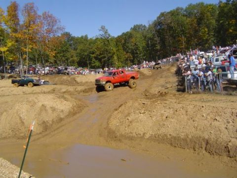 1979 Ford Bronco - Mud bog event with multiple trucks and spectators enjoying the off-road action.