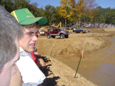 1979 Ford Bronco - Spectators watch trucks navigate a muddy course during a mud bogging event.