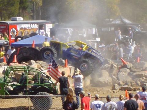 1979 Ford Bronco - Off-road vehicles compete on a challenging rocky terrain during an event with many onlookers.