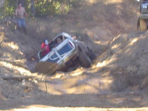 1979 Ford Bronco - Off-road vehicles stuck in mud during an event.