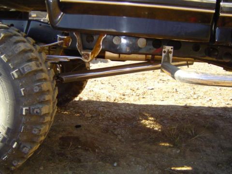 1979 Ford Bronco - The underside of a vehicle shows heavy-duty suspension and large tires, suggesting off-road modifications.