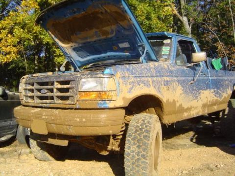 1979 Ford Bronco - This muddy blue pickup truck has its hood open, suggesting it may have encountered some trouble during the mud bash.