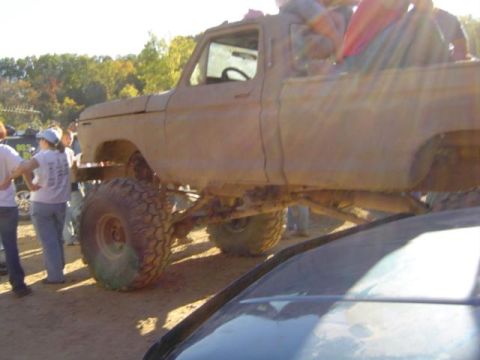 1979 Ford Bronco - A lifted pickup truck with large tires is seen at an outdoor event.