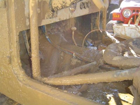 1979 Ford Bronco - Two vehicles are heavily covered in mud after an off-road event.