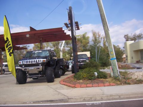 1999 Jeep TJ - Hummer H2 and another truck are parked outside under a covered structure.