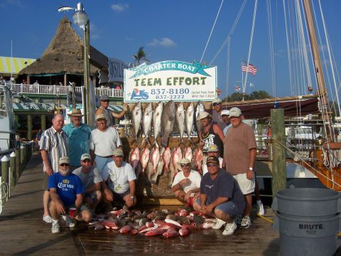 1999 Jeep TJ - A group of fishermen proudly display their impressive catch of fish on a sunny day at the dock.