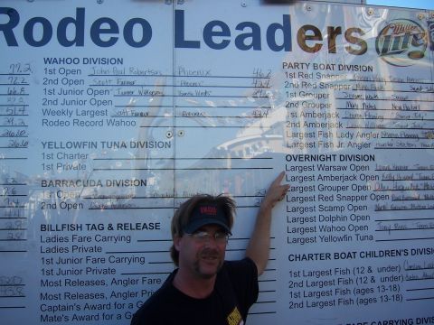 1999 Jeep TJ - A man points to a scoreboard displaying fishing tournament results for various divisions.