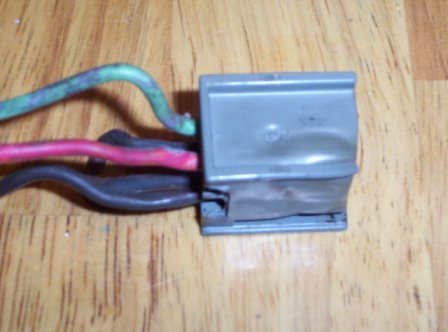1978 Ford Mustang II - A close-up shows an electrical connector with three wires attached, set against a wooden background.