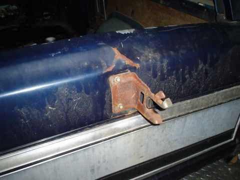 1984 Ford Bronco - Close-up of a rusted interior door latch mechanism on a blue vehicle.