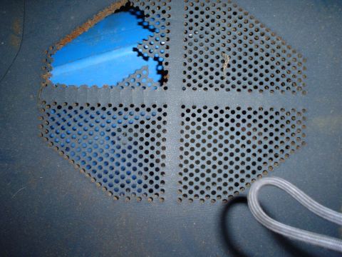 1984 Ford Bronco - A close-up view of a damaged perforated metal vent with visible blue insulation underneath.