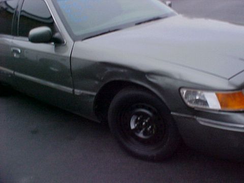 2000 Mercury Grand Marquis - Front quarter view of a 2000 Mercury Grand Marquis showing the fender, door, and wheel.
