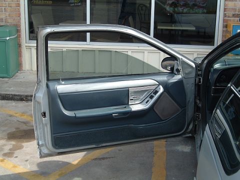 1994 Ford Thunderbird - Interior door panel of a 1994 Ford Thunderbird, blue and silver accents.