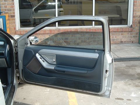 1994 Ford Thunderbird - The interior door panel of a car is visible with the door open.