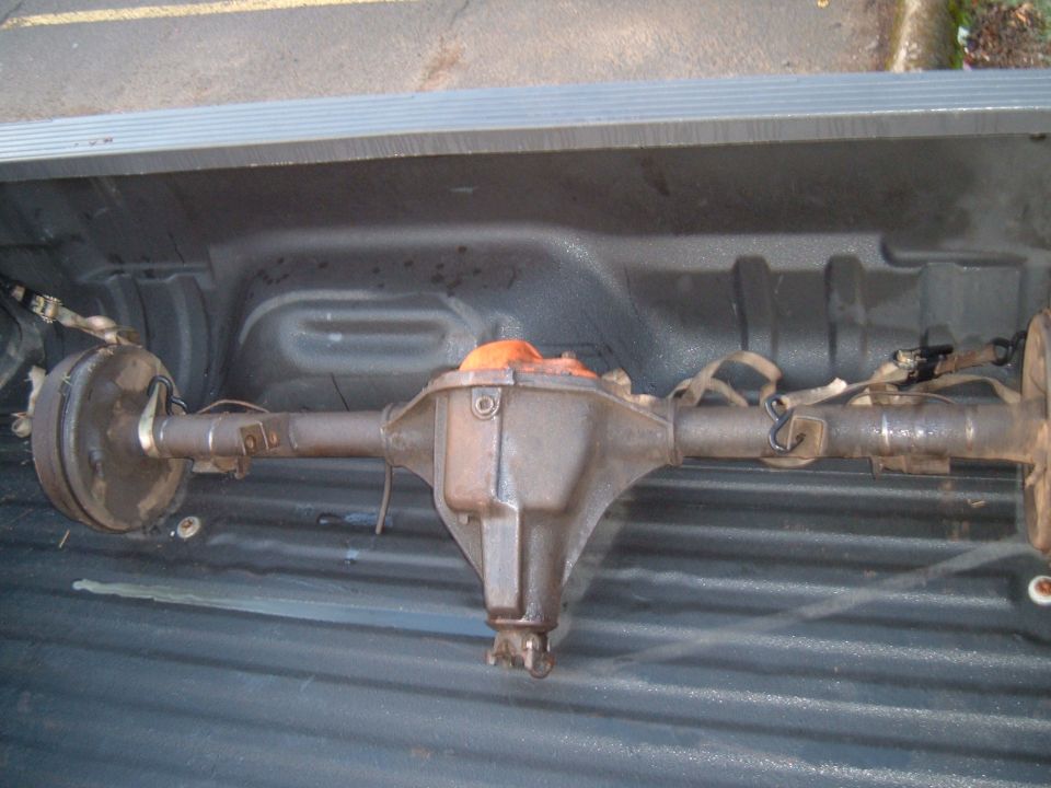 Rear axle assembly with drum brakes, strapped in a truck bed