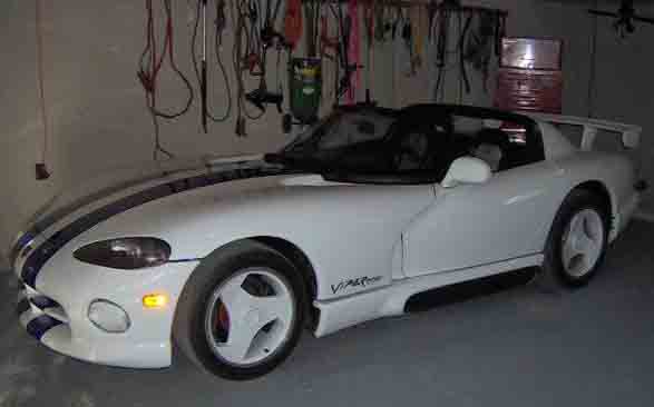 White convertible sports car with blue stripes and a rear spoiler