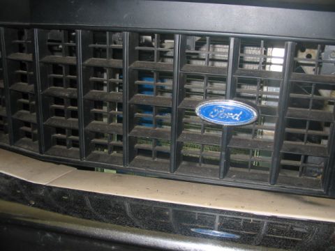 1985 Ford Crown Victoria LTD - The front grille of a Ford vehicle, the iconic blue oval emblem.