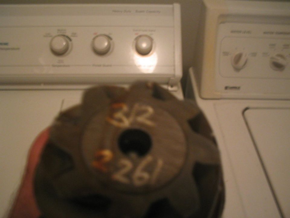 Gear part with handwritten numbers '3/2' and '261' in yellow and orange